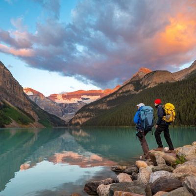 Link zur Beschreibung der Sonderveranstaltung „Kanada - Durch Wildnis und Weite“ - Das Bild zeigt Achill und Aaron Moser, die an einem See in Kanada stehen. Sie schauen auf den See. Im Hintergrund befinden sich Wälder und Berge.